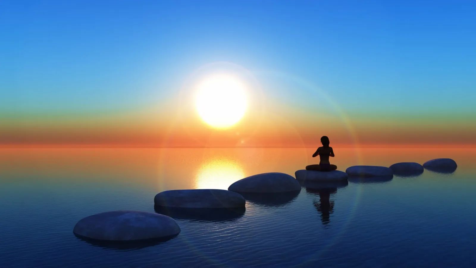 Person Sitting On Large Rocks On A Beach In A Meditative Position