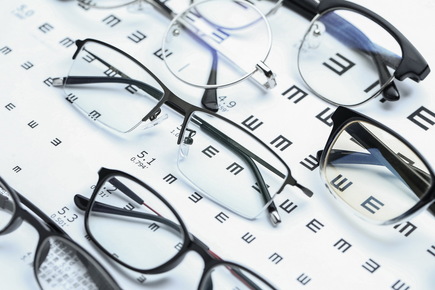 Eyeglasses Sitting on Top Of An Eyechart On a Table