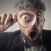 Photo Of Man Holding Magnifying Glass Close To His Eye