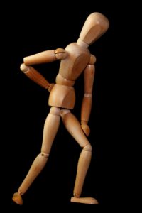 Image of Wooden figure bent over from back pain.