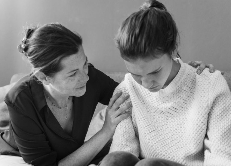 Sad Young Woman Being Comforted By Her Mother